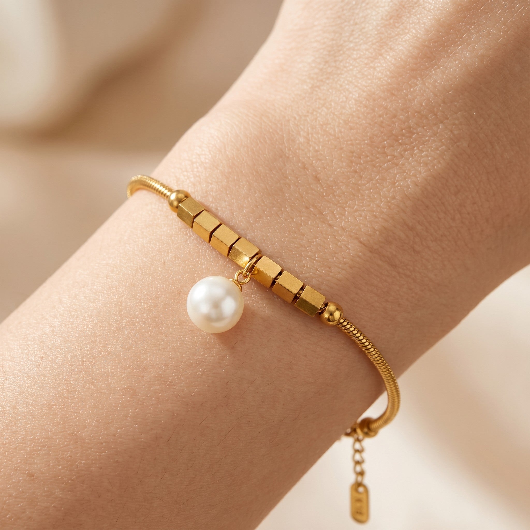Złota Kraków gold-plated surgical steel bracelet with a synthetic pearl charm and cube accents.