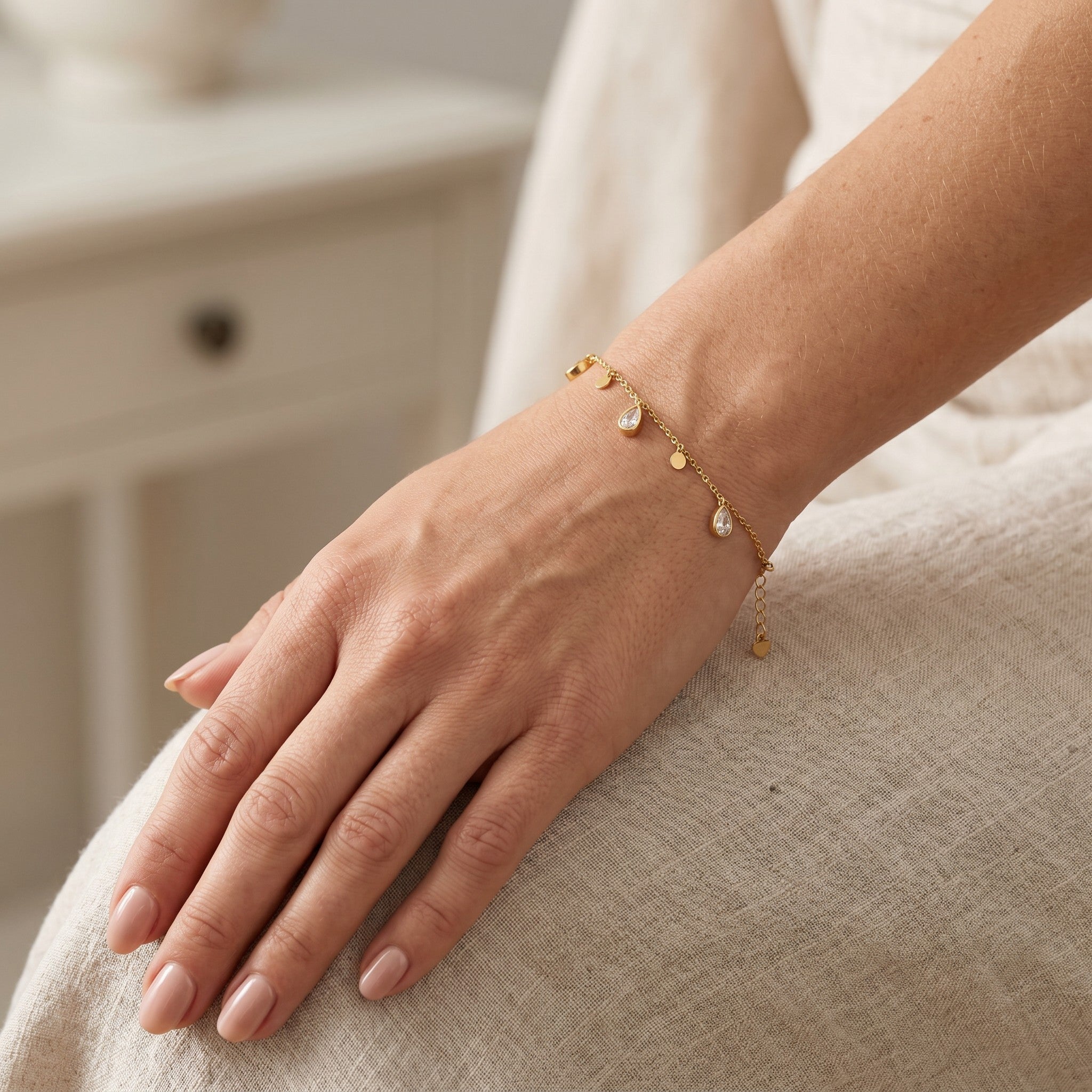 Złota Kraków gold-plated surgical steel bracelet with charms including teardrop crystals and small discs.