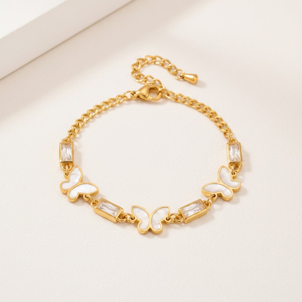 Złota Kraków gold-plated surgical steel bracelet with white mother-of-pearl butterfly charms and clear baguette crystals.
