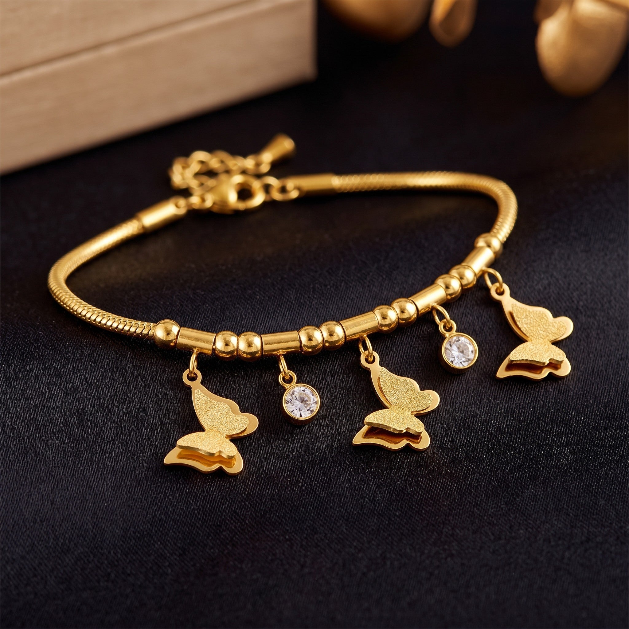 Złota Kraków gold-plated surgical steel bracelet with butterfly charms and clear cubic zirconia accents. Adjustable length.